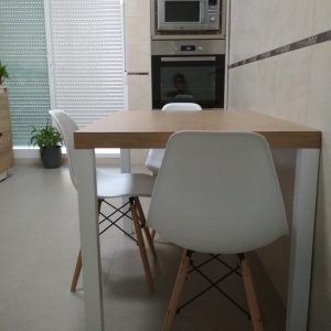 Mesa de comedor color natural con patas blancas y sillas a juego de plástico