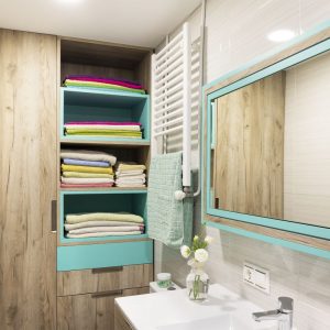 baño con mueble y espejo en color madera y aguamarina