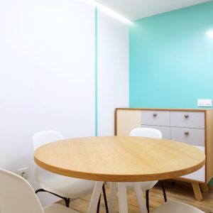 Diseño de oficina de Abraite con mesa de reuniones y mueble auxiliar, y un escritorio al fondo