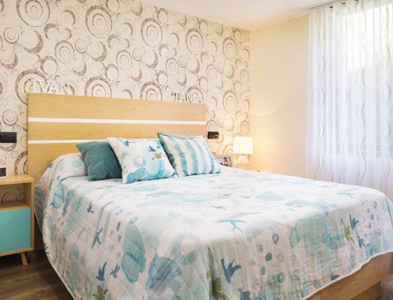 dormitorio de matrimonio color crema con detalles en azul aguamarina