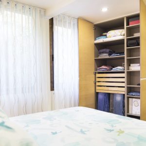 dormitorio blanco con armario en madera y cama de matrimonio