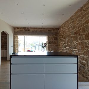 Cocina en blanco y negro con pared de piedra