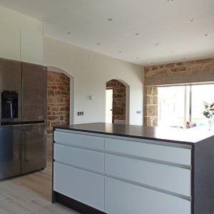 Cocina en blanco y negro con pared de piedra