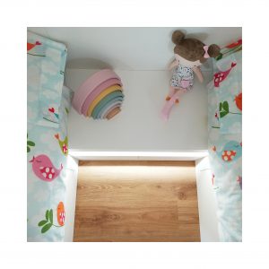 Mesita de noche blanca entre dos camas gemelas en dormitorio infantil