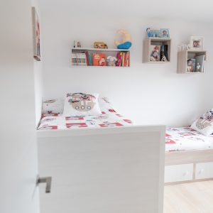 Habitación infantil con dos camas y estanterías