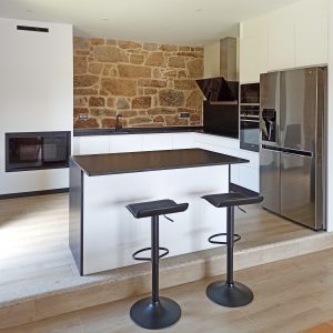 Cocina en blanco y negro con pared de piedra