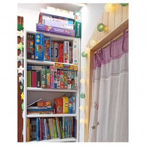 Habitación de juegos para niños, decorada con panelado de madera, estanterías y luces